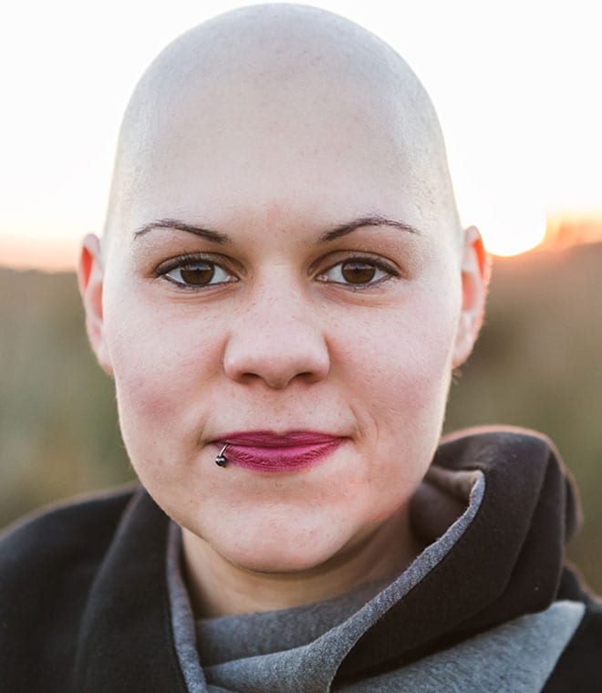 Woman with a shaved head smiling