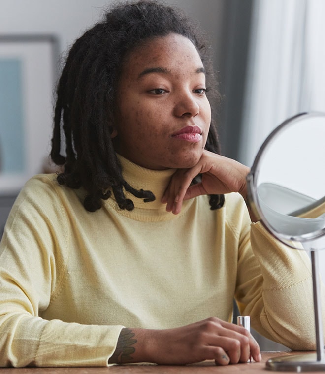 Young black woman looking in a mirror