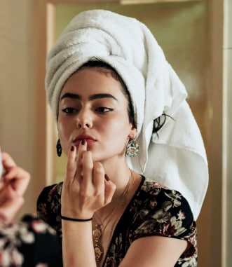 Girl doing makeup in mirror