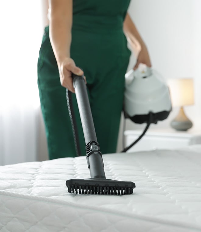 Woman vacuuming a mattress