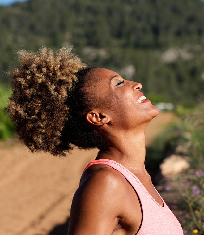 Millennial black woman smiling into the sun