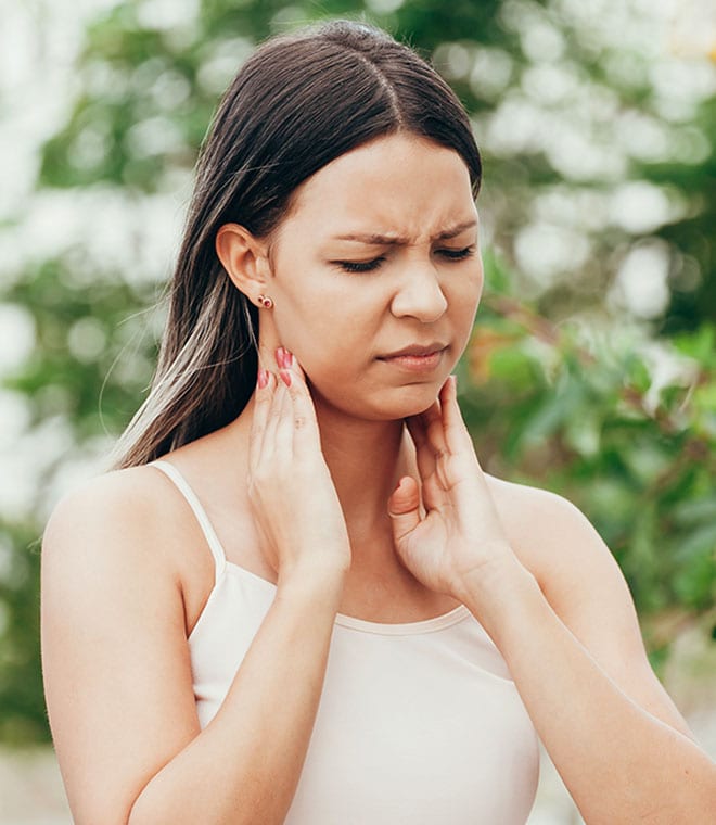 Millennial woman touching her throat in pain