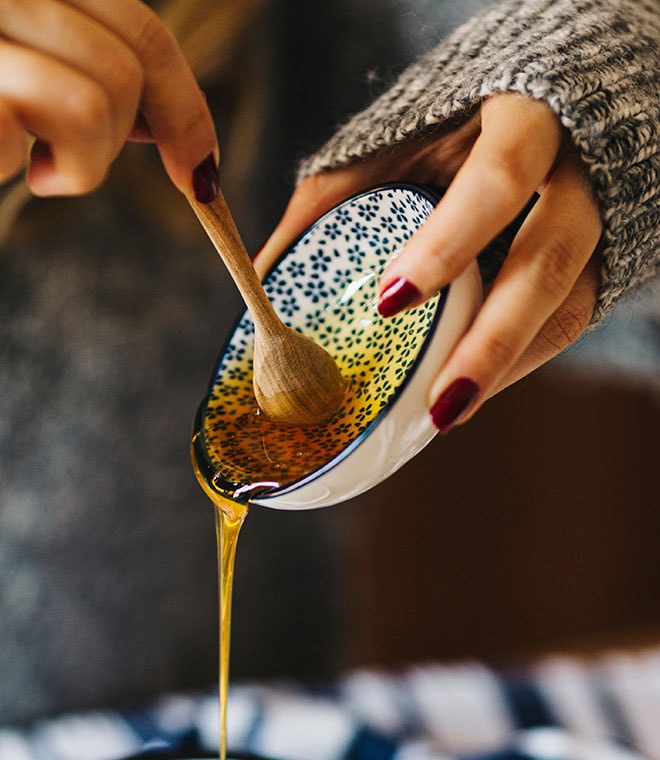 Woman pouring honey out of a dish
