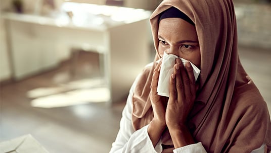 Muslim woman blowing her nose