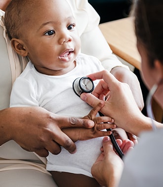 Black baby getting examined by a doctor