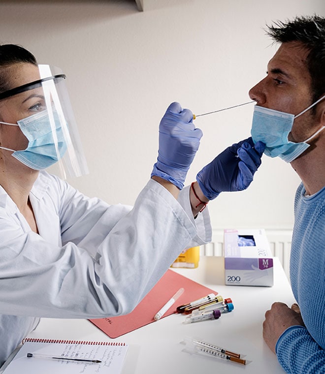 White female doctor giving white male patient a flu test