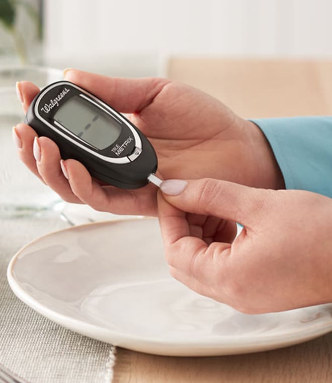 Person holding glucose monitor