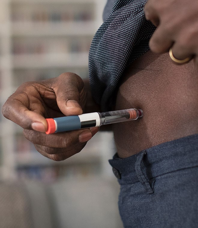 Black man giving himself an insulin shot