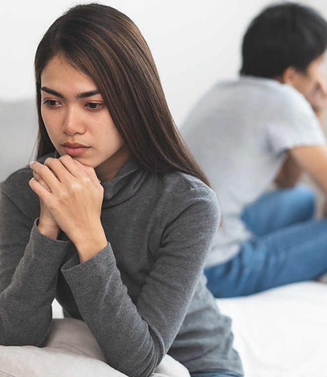 Young couple facing away from each other looking worried