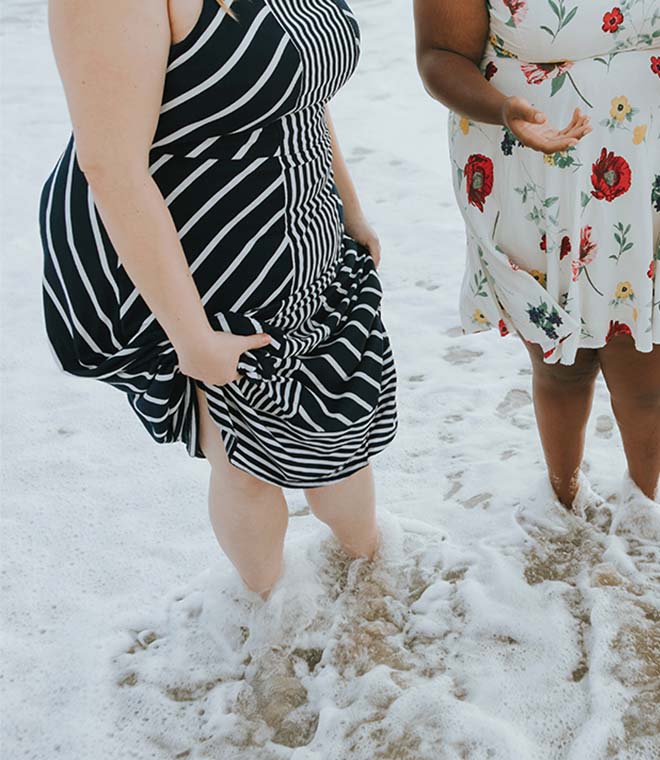 Two women wetting their feet in the ocean