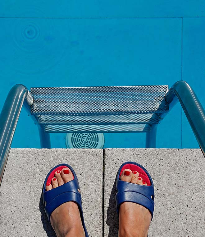 Woman in sandals standing over a pool