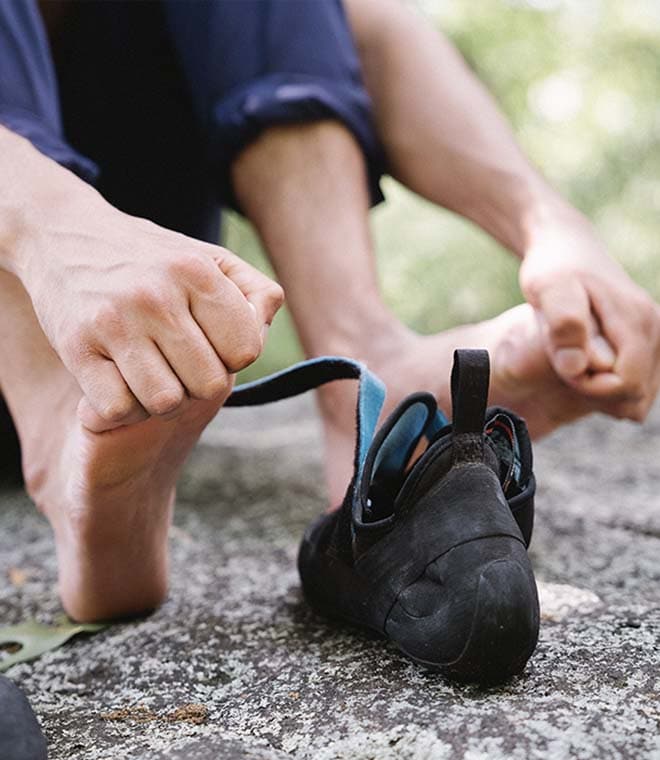 Person removing shoes and rubbing sore feet