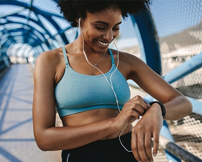 Black woman looking at her watch after a run