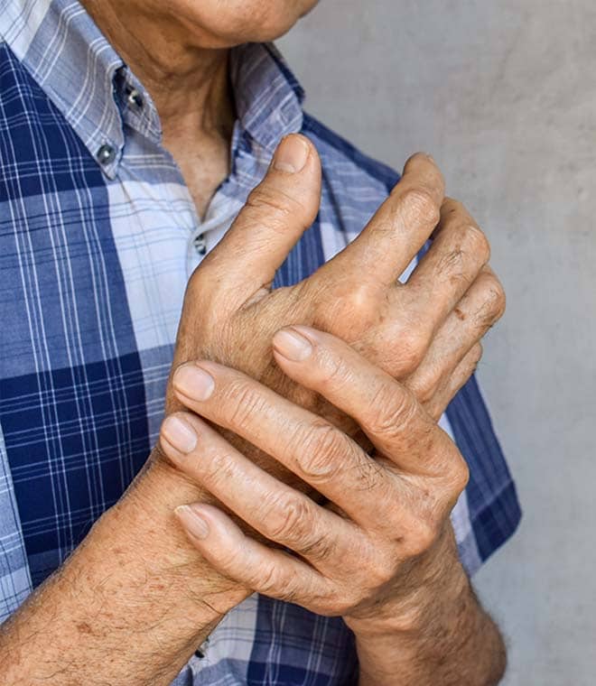 Older man holding his hands in pain