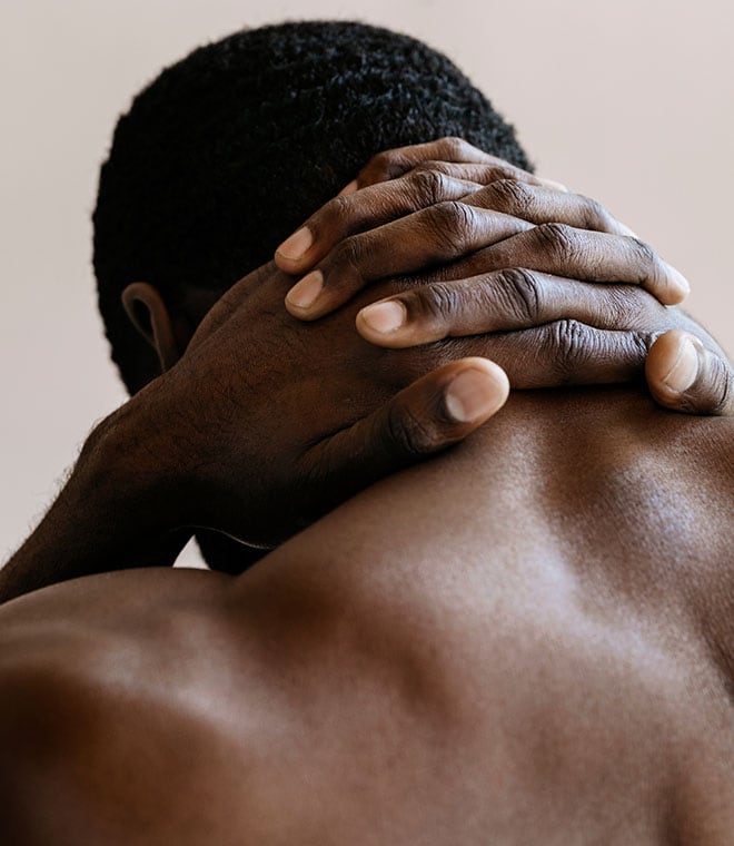 Black man clasping his hands over his neck
