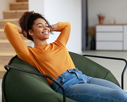 Calm black woman resting on a cushioned chair
