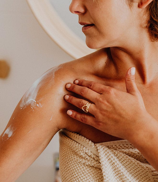 Woman rubbing lotion into her shoulder