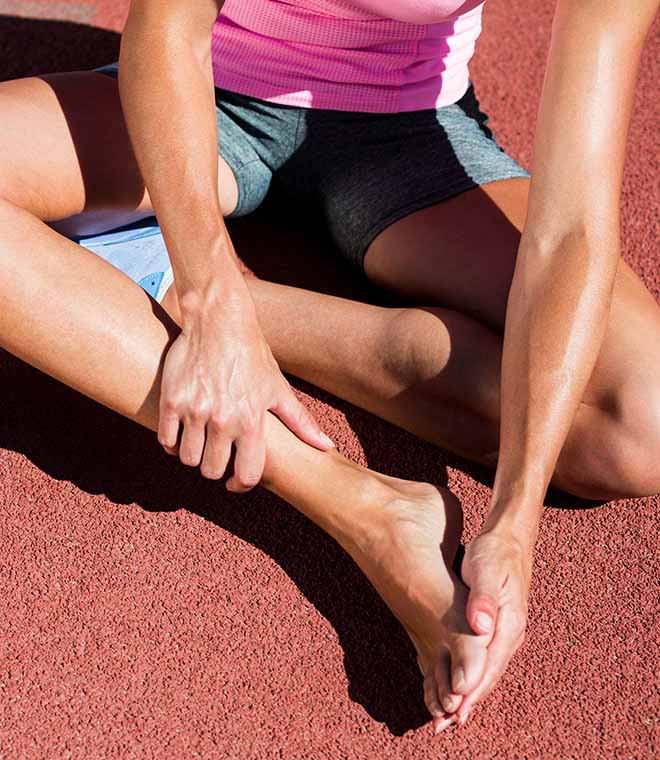 Athlete rubbing the bottom of their foot on a track