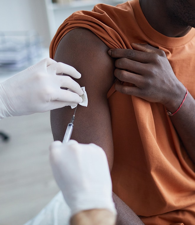 Black man getting a shot in his arm