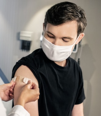 Young man getting band aid after vaccine