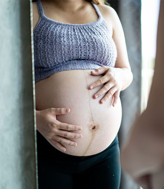 Pregnant white woman holding her stomach