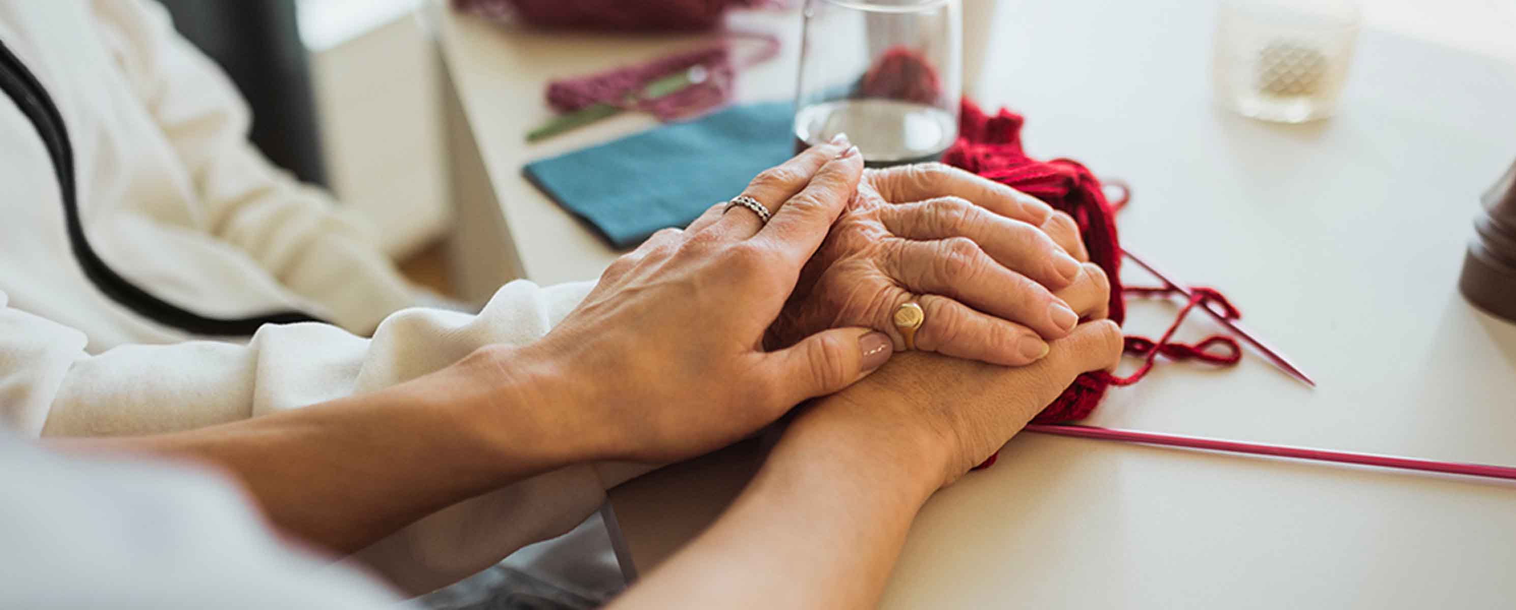 White woman holding hand of older person