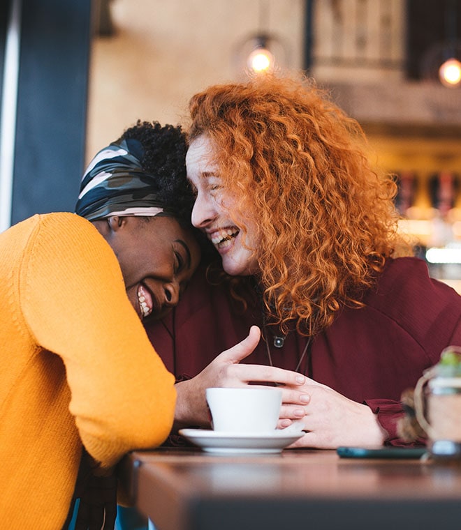 Two women laughing in a cafe