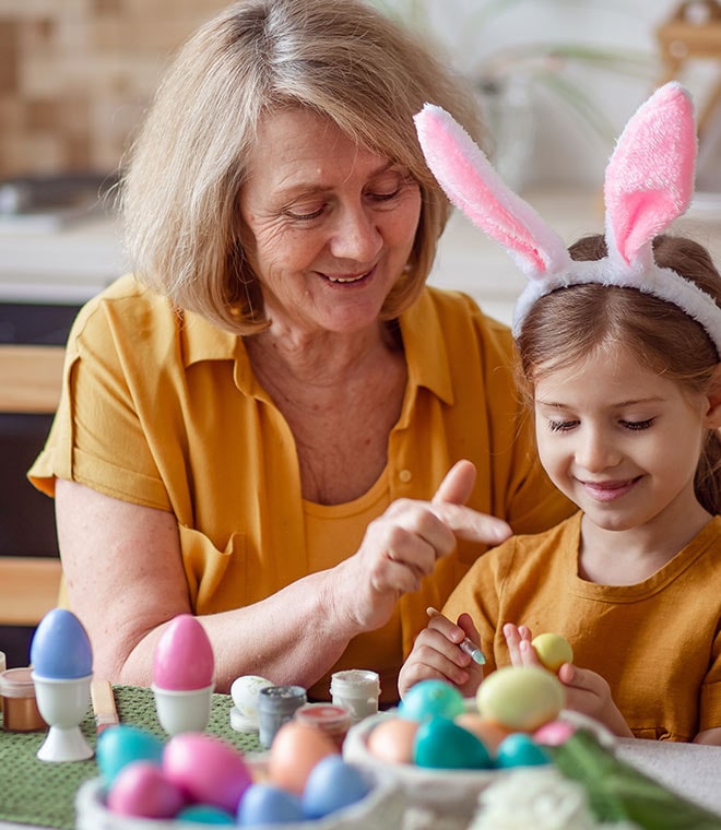 Old woman playing with young girl with bunny headband