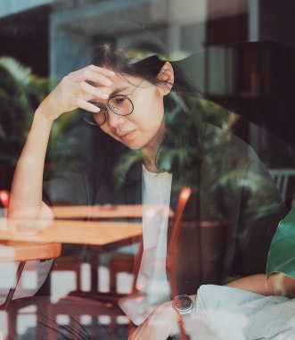 Asian woman stressed looking through window
