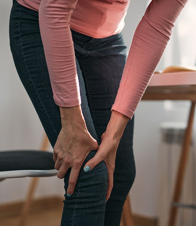 Woman grabbing her knee in pain
