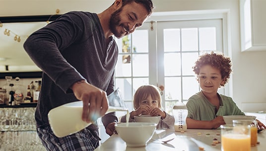 Young family pouring a bowl of cereal