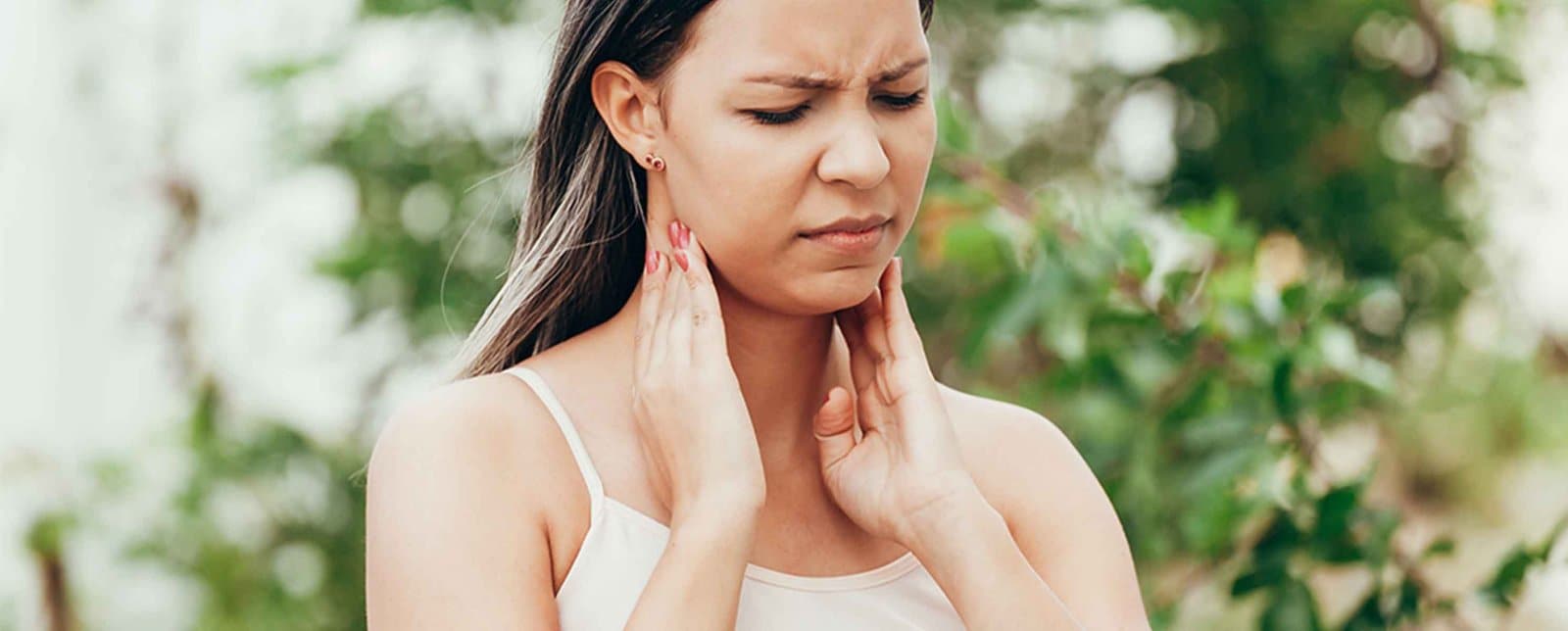 woman holding her sore throat
