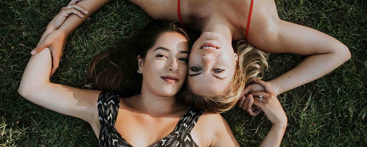 Two  young women laying in the grass
