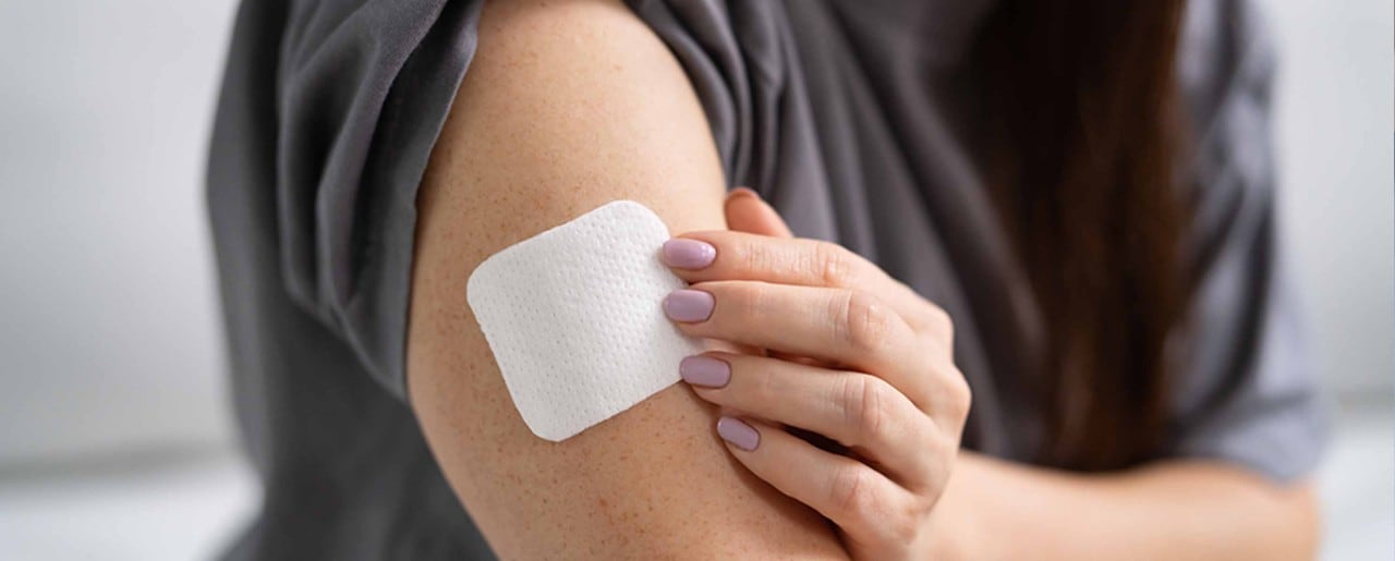 White woman with nicotine patch on her arm