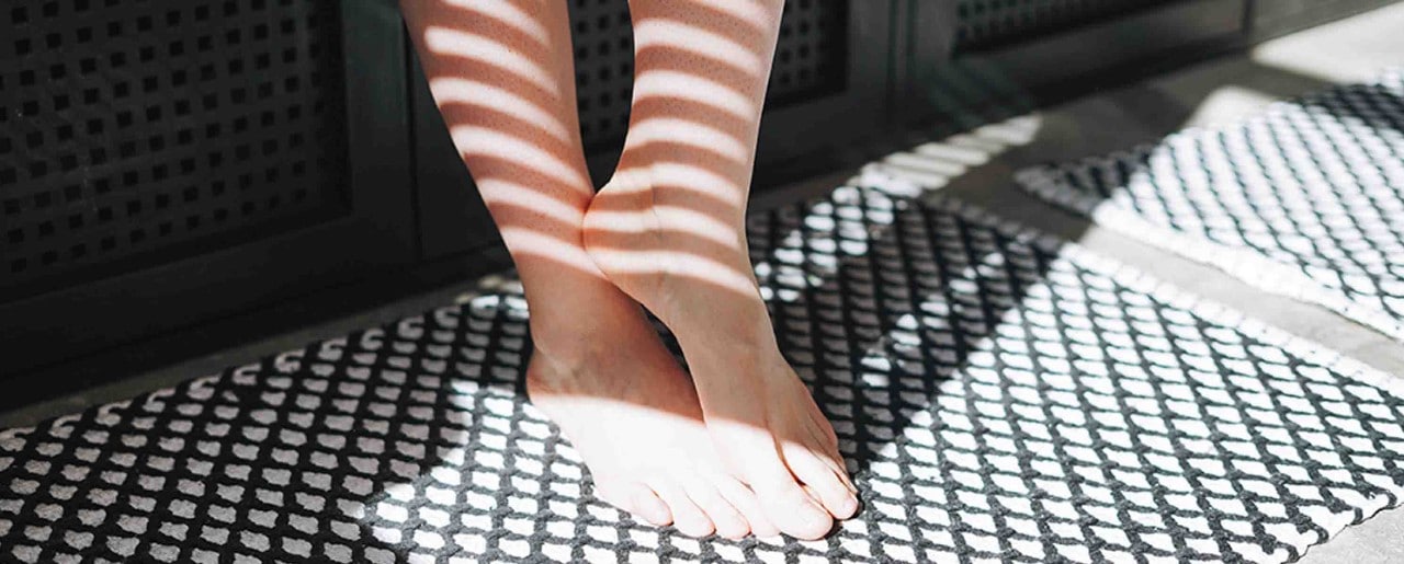 White woman's feet in slatted sunlight