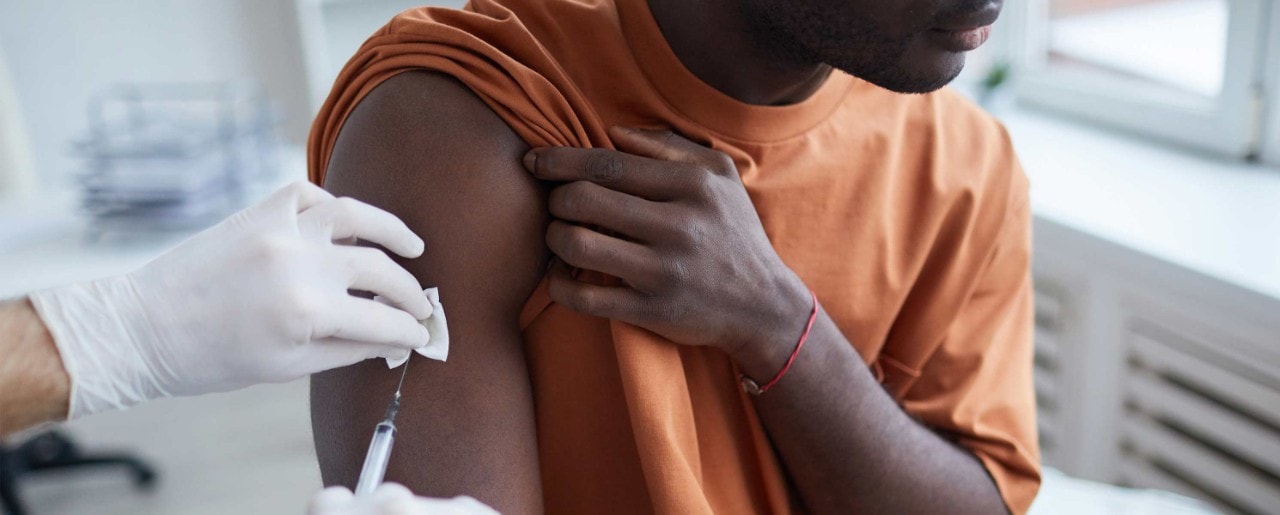 Black man getting a shot in his arm