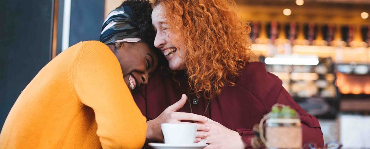 Two women laughing in a cafe