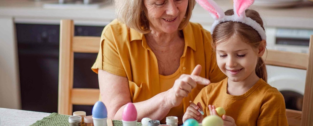 Old woman playing with young girl with bunny headband